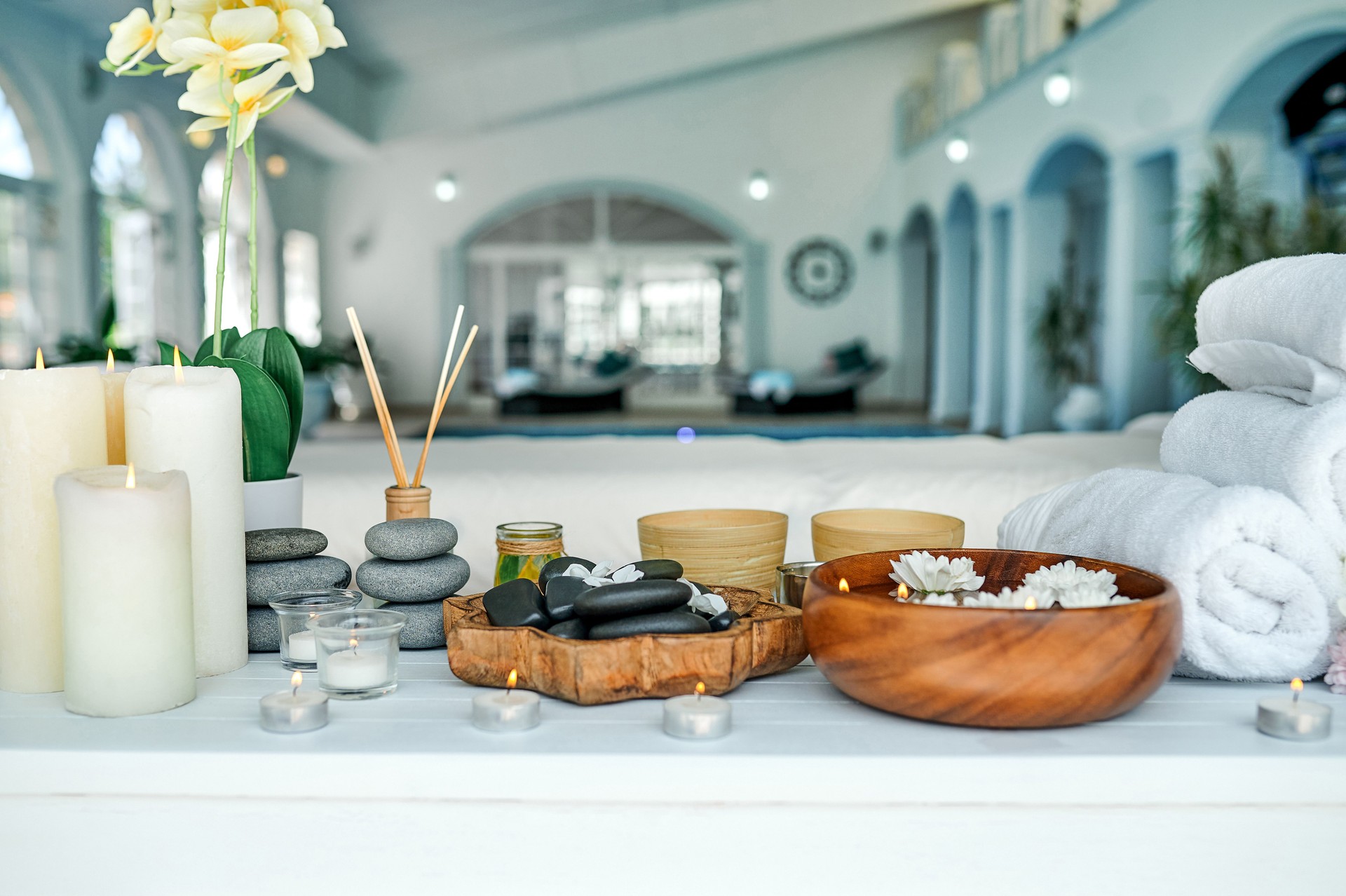 Shot of hot stones, towels and a bowl of water on a table in an empty spa